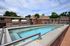 Luxurious rooftop space featuring a sparkling hot tub, modern grills, and inviting seating, perfect for relaxation and entertaining.