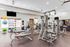 Modern fitness center with state-of-the-art equipment, free weights, and ample natural light creating an inviting workout space.