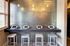 Modern workspace with sleek bar seating and integrated tablets under elegant pendant lighting.