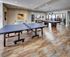 Elegant recreation room with a ping pong table and pool table on polished wooden floors, ideal for entertainment and leisure.