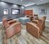 Inviting media room with plush recliners, modern decor, and a large screen for ultimate relaxation.