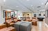 Elegant recreation room with plush armchairs, modern decor, and games area featuring foosball and ping pong tables.