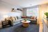Inviting living room with a modern gray sectional, cozy pillows, and stylish decor, bathed in natural light from a large window.