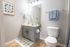Bright and charming bathroom with stylish vanity, elegant mirror, and cozy decor, perfect for relaxation.