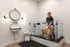 Modern pet-friendly bathroom featuring a stylish dog-washing station with subway tiles, complete with a joyful dog enjoying a bath.