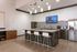 Modern kitchen with sleek countertops, stylish bar stools, and elegant pendant lighting, perfect for entertaining and culinary delight.