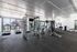 Spacious and modern gym with state-of-the-art equipment, large windows, and scenic outdoor views.