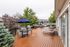 Inviting outdoor deck featuring modern lounge chairs, stylish patio umbrellas, and sleek BBQ grills surrounded by lush greenery.