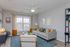 Bright and inviting living room featuring a large window with scenic views, stylish gray sofa adorned with colorful cushions, and modern decor elements.