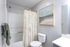 Bright and elegant bathroom featuring modern fixtures, a stylish shower curtain, and tasteful wall art.