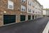 Modern apartment complex with elegant stonework facade and multiple garages, offering convenient and stylish urban living.