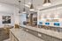 Elegant open-concept lounge featuring modern granite countertops, cozy fireplace, and stylish workspace with 'Joie de Vivre' decor.