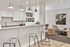 Elegant open kitchen and living area with modern bar seating, chic pendant lighting, and stylish decor, offering a cozy and inviting ambiance.