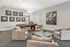 Elegant game room featuring a stylish billiard table, modern art decor, and cozy seating arrangement.