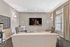 Elegant modern living room featuring cozy seating, a sleek flat-screen TV, stylish decor, and abundant natural light from large windows.