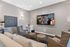 Chic home theater room with cozy seating, wall-mounted TV, and stylish decor featuring a popcorn machine and modern furniture.