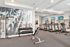 Inviting fitness center featuring modern cardio equipment, free weights, and motivational wall art in a bright, spacious setting.