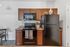 Contemporary kitchen with sleek black appliances, elegant wooden cabinetry, and a cozy dining area.