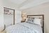 Inviting bedroom with cozy patterned bedding, soft lighting, and ample closet space for a tranquil living experience.