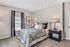 Elegant bedroom with plush carpeting, artistically adorned with elephant artwork, featuring a cozy bed with stylish bedding and sophisticated bedside lamps.
