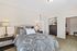 Inviting bedroom featuring a plush bed with elegant paisley bedding, tasteful decor, and ample closet space.