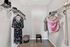 Spacious walk-in closet featuring elegant clothing on display and ample shelving, perfect for organizing and showcasing your wardrobe.