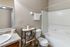 Modern bathroom featuring sleek fixtures, a granite countertop, and elegant shelving for a stylish touch.