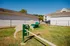 Inviting pet play area with agility equipment and lush green surroundings, set within a vibrant apartment community.