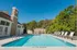 Inviting outdoor pool area with stylish lounge chairs, surrounded by lush greenery, perfect for relaxation and enjoyment.