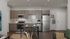 Modern kitchen with sleek wooden cabinetry, stainless steel appliances, and a cozy dining area for two, offering a stylish and functional space.
