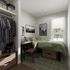 Cozy bedroom setup with a stunning view, featuring a stylish workspace and ample closet storage.