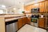Warm and inviting kitchen with modern appliances, sleek countertops, and elegant lighting, perfect for effortless entertaining.