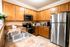 Inviting kitchen with modern stainless steel appliances, warm wooden cabinetry, and cozy countertop decor.