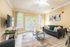 Inviting living room with stylish decor, featuring a comfortable grey sofa, modern wall art, and ample natural light streaming through French doors.