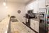 Modern kitchen with sleek granite countertops, stainless steel appliances, and elegant pendant lighting.