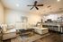 Chic open-plan living room with cozy sectional sofa, modern kitchen with breakfast bar, and elegant decor.