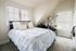 Charming bedroom with abundant natural light, featuring a cozy bed, elegant desk area, and stylish decor.