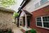 Charming apartment exterior with brick and stone detailing, lush landscaping, and modern architectural design.
