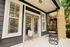Charming patio with stylish hanging chair and modern plant decor, enhancing outdoor relaxation.