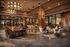 Modern communal living space with chic seating areas, a long wooden table for collaboration, and ambient lighting, perfect for social gatherings and productivity.