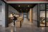 Modern apartment hallway with sleek lighting, secure mailroom, and a peaceful study nook visible through glass walls.
