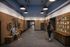 Modern apartment corridor with artistic bicycle wall decor and cozy benches, illuminated by stylish pendant lights.
