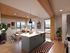 Modern apartment with open-concept living room and kitchen, featuring stylish wood accents, large windows with city views, and chic d&eacute;cor.