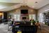 Inviting living space showcasing modern design with vaulted ceilings, chic fireplace, and ample natural light streaming through double doors.