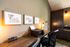 Chic home office with wood desk, modern lighting, and framed art creating a cozy, productive atmosphere.