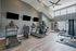 Modern fitness center with state-of-the-art equipment including treadmills, elliptical machine, multiple TV screens, and bright windows.