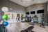 Modern fitness center featuring state-of-the-art exercise equipment, wall-mounted TVs, and vibrant exercise balls in a sleek, inviting atmosphere.