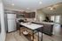 Modern kitchen with stainless steel appliances, stylish countertops, and open living area connected to a bright, inviting space.