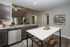 Elegant modern kitchen with marble countertops, stainless steel appliances, and stylish open shelving in a cozy apartment layout.