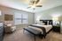 Inviting bedroom featuring modern decor, ample natural light, and cozy seating area.